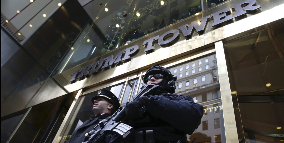 epa05671380 An armed NYPD police officer stands guard outside the entrance to Trump Tower in New York City, New York, USA, 11 December 2016. US President-elect Donald Trump is still holding meetings upstairs at Trump Tower as he continues to fill in key positions in his new administration. EPA/JOHN ANGELILLO / POOL