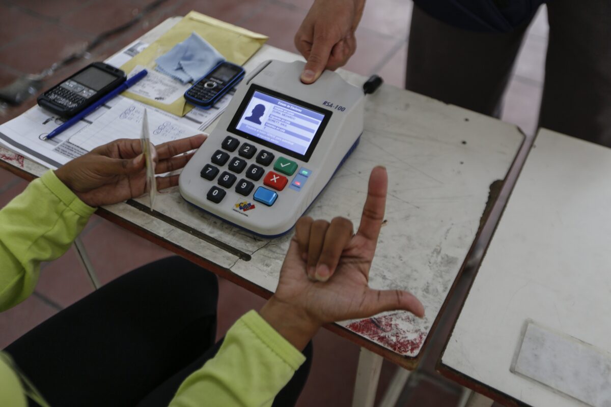 epa06118218 A polling official checks identification as Venezuelans vote in the elections of the National Constituent Assembly, in Caracas, Venezuela, 30 July 2017. The voting on a constituent assembly takes place under strict security measures and despite the rejection of local opposition and the international community. The new assembly would have powers to rewrite a constitution and bypass the National Assembly which is currently controlled by the opposition. EPA/NATHALIE SAYAGO